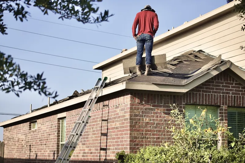 Professional roofer working on a residential roof in McPherson